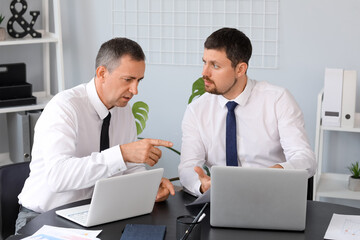 Male business consultants working at table in office