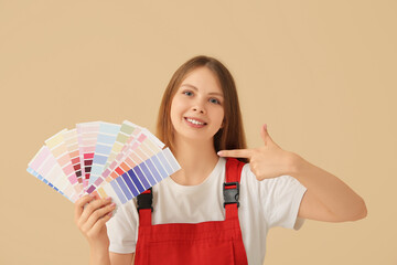 Female decorator with color samples on beige background