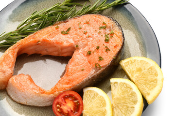 Plate of tasty fried salmon steak with lemon on white background