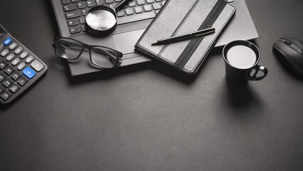 Business desk with laptop calculator glasses notebook pen mouse and coffee cup