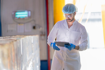 A meticulous male scientist in a sterile environment meticulously documents quality control data on...
