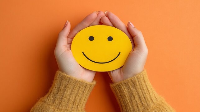 Female hands holding a yellow smiley face