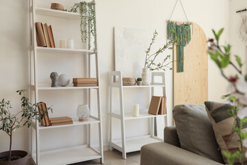 Shelving unit and vase with blooming branches in room