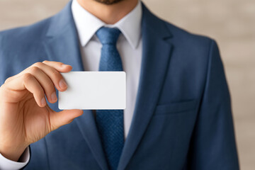 Close-up of a businessman in a blue suit holding a blank white card