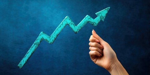 Hand holding a teal upward trending arrow against a blue background indicating growth and success