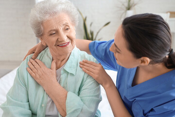 Obraz premium Physical therapist hugging senior woman in bedroom, closeup