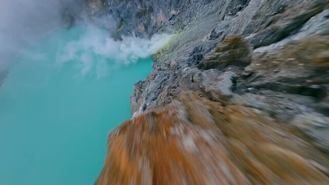 Cinematic FPV drone flight into Ijen Volcano crater lake, East Java, with dramatic sulfur steam and vivid turquoise water. Raw geology, surreal landscape, and volcanic beauty.
