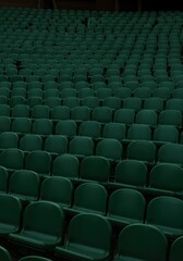 Fototapeta premium A wide, elevated view of an empty auditorium filled with countless dark green seats