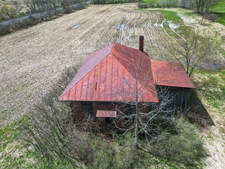 An abandoned building in a harvested corn field in Columbus, Pennsylvania, USA on a sunny spring day