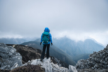 Obraz premium Successful woman hiker climbing to mountain top in tibet