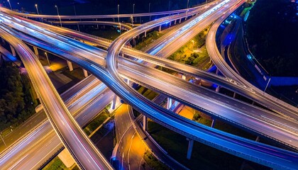 Aerial view of a complex highway interchange at night, illuminated by lights.