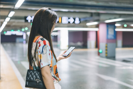 Woman using smartphone in an indoor parking lot