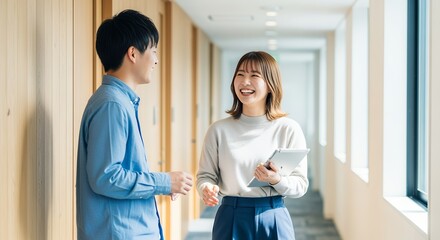 オフィス廊下で談笑する若い同僚