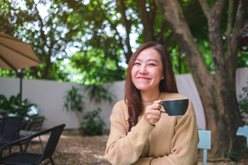 Portrait image of a woman drinking coffee in the outdoors cafe