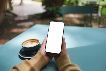 Mockup image of a woman holding mobile phone with blank screen in the outdoors