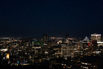 Fototapeta premium Panoramic Montréal skyline at night, modern skyscrapers glowing above the river.