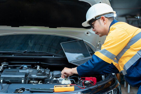 Asian male automotive technician who inspects, repairs, and maintains all vehicle systems,ensuring safe and optimal performance through expertise in engines, brakes, transmissions electrical systems