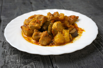 Savory Plate of Pudla: Traditional Meat and Potato Dish on Rustic Wooden Table