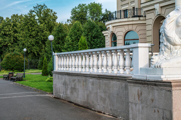 Fototapeta premium White balustrade on the background of the facade of the building. Vintage place for a photo shoot. Backstage.