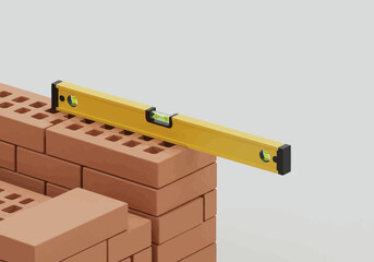 Yellow spirit level checking the straightness of a red brick wall during construction, symbolizing accuracy and quality work.