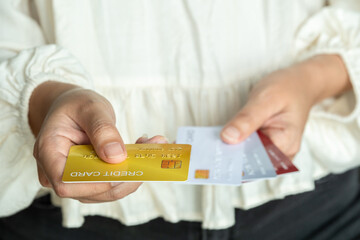 Woman holding several credit cards and he is choosing a credit card to pay and spend Payment for...