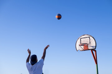 Man shooting basketball towards hoop