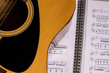 a guitar with a music book. with space for the text. close-up. lifestyle