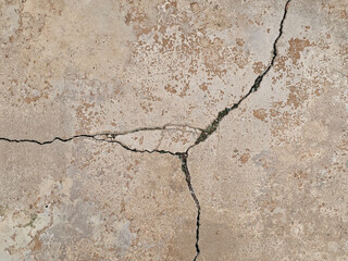Long cracks in the ground cement concrete surface may be caused by earthquake or poor construction.