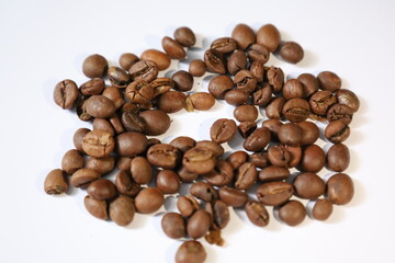 Roasted brown coffee beans, isolated on a white background, form a heap, ready for a rich, dark...