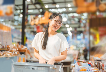 Young adult asian woman consumer choosing ready meals cooked food at supermarket store choice buying