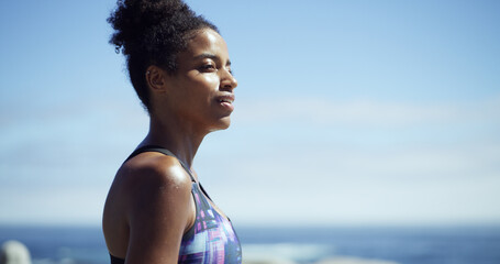 Black woman, fitness and break at beach, promenade or thinking with space, sky and smile. African...
