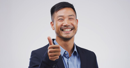Happy asian man, portrait or thumbs up in studio for good job or OK on a white background. Face,...