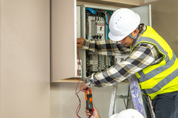 Skilled electrician worker inspecting electrical panel with multimeter testing wi in residential building for safety and maintenance purposes