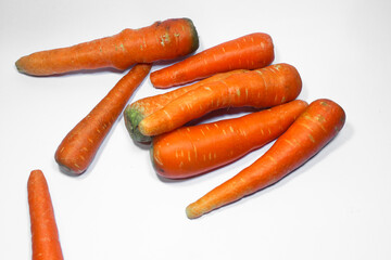 Fresh organic carrots stacked on a clean white background. A healthy root vegetable rich in vitamin A, perfect for cooking, juicing, or raw consumption.