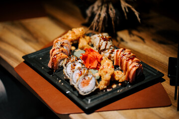 Fresh sushi platter presented on a dark plate in an elegant restaurant setting
