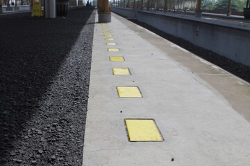 Modern Railway Platform With Yellow Markings and Urban Architecture
