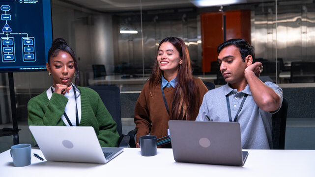 Confident African American businesswoman leading a diverse team of professional colleagues in a night office meeting, discussing project strategy and collaboration for corporate growth.