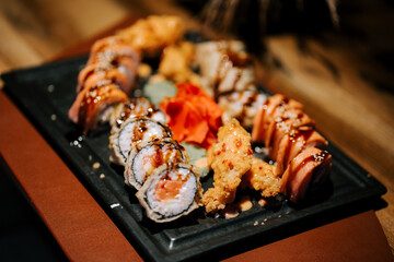 Delicious sushi platter featuring various rolls and shrimp tempura served in an elegant setting