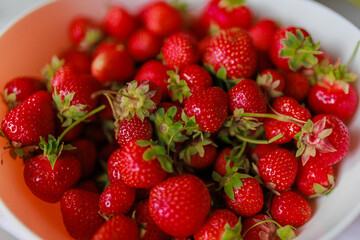 Fresh sweet strawberries in a white bowl on a white background. Seasonal berries.