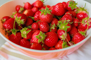 Fresh sweet strawberries in a white bowl on a white background. Seasonal berries.