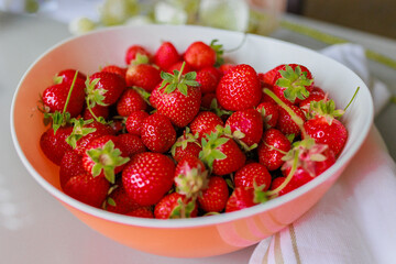 Fresh sweet strawberries in a white bowl on a white background. Seasonal berries.