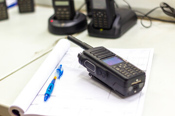 Professional Two-Way Radio on Desk with Notebook