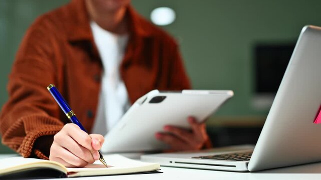 businessman hand working with new modern computer and writing on the notepad strategy diagram as concept