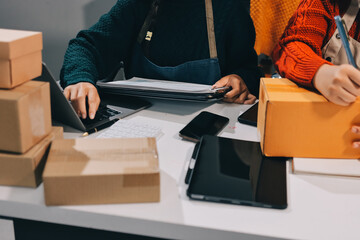 Portrait of Starting small businesses SME owners, two Asian woman check online orders Selling products working with boxs freelance work at home office, sme business online small medium enterprise