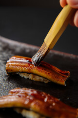 鰻の握り寿司　寿司職人が刷毛でタレを塗っている