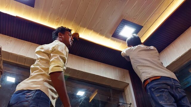 Two Men Glue Roof Panels for Store Makeover