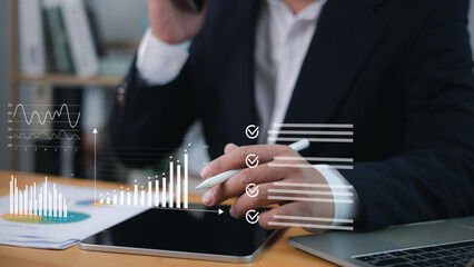 Professional analyzing business data on tablet with stylus while managing a digital checklist,...