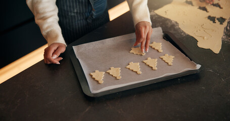Christmas, hands or child baking with tray in kitchen for festive tradition, recipe or food....