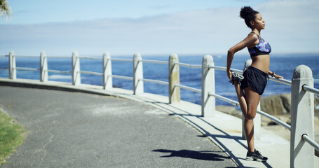 Black woman, exercise and stretching legs at beach promenade, ready or thinking for fitness....