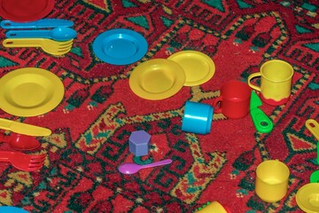 Children's toys are lying on an old carpet in close-up